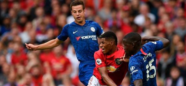 Manchester United's English striker Marcus Rashford (C) is fouled by Chelsea's French defender Kurt Zouma (R) to win a penalty leading to the opening goal during the English Premier League football match between Manchester United and Chelsea at Old Trafford in Manchester, north west England, on August 11, 2019. (Photo by Oli SCARFF / AFP) / RESTRICTED TO EDITORIAL USE. No use with unauthorized audio, video, data, fixture lists, club/league logos or 'live' services. Online in-match use limited to 120 images. An additional 40 images may be used in extra time. No video emulation. Social media in-match use limited to 120 images. An additional 40 images may be used in extra time. No use in betting publications, games or single club/league/player publications. /         (Photo credit should read OLI SCARFF/AFP/Getty Images)