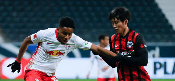 FRANKFURT AM MAIN, GERMANY - NOVEMBER 21: Christopher Nkunku (L) of Leipzig is challenged by Daichi Kamada of Frankfurt  during the Bundesliga match between Eintracht Frankfurt and RB Leipzig at Deutsche Bank Park on November 21, 2020 in Frankfurt am Main, Germany. Football Stadiums around Europe remain empty due to the Coronavirus Pandemic as Government social distancing laws prohibit fans inside venues resulting in fixtures being played behind closed doors. (Photo by Ronald Wittek - Pool/Getty Images)