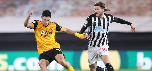 WOLVERHAMPTON, ENGLAND - OCTOBER 25: Raul Jimenez of Wolverhampton Wanderers is challenged by Jeff Hendrick of Newcastle United during the Premier League match between Wolverhampton Wanderers and Newcastle United at Molineux on October 25, 2020 in Wolverhampton, England. Sporting stadiums around the UK remain under strict restrictions due to the Coronavirus Pandemic as Government social distancing laws prohibit fans inside venues resulting in games being played behind closed doors. (Photo by Alex Pantling/Getty Images)