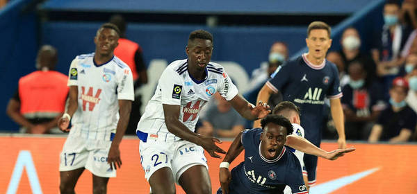PARIS, FRANCE - AUGUST 14: Arnaud Kalimuendo of Paris Saint-Germain  is brought down by Ibrahima Sissoko of RC Strasbourg Alsace  during the Ligue 1 Uber Eats match between Paris Saint Germain and Strasbourg at Parc des Princes on August 14, 2021 in Paris, France. (Photo by David Rogers/Getty Images)