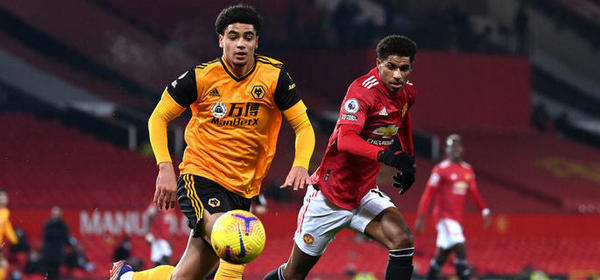 MANCHESTER, ENGLAND - DECEMBER 29: Ki-Jana Hoever of Wolverhampton Wanderers runs with the ball under pressure from Marcus Rashford of Manchester United during the Premier League match between Manchester United and Wolverhampton Wanderers at Old Trafford on December 29, 2020 in Manchester, England. The match will be played without fans, behind closed doors as a Covid-19 precaution. (Photo by Laurence Griffiths/Getty Images)